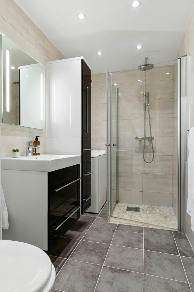 Contemporary bathroom interior featuring sleek glass shower and elegant fixtures.