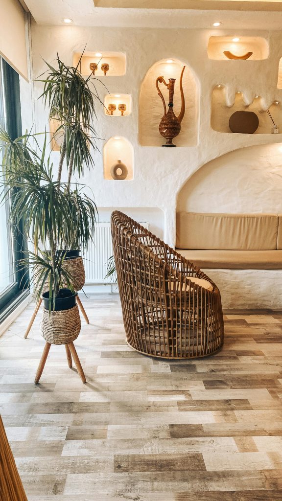Contemporary living room with bamboo chair, potted plants, and modern decor. Ideal for cozy interiors.